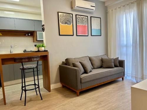 ein Wohnzimmer mit einem Sofa und einer Küche in der Unterkunft Apto 28A - Residencial Palladium Centro, Penha SC in Penha