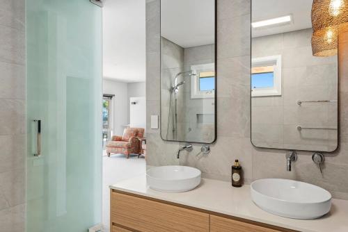 a bathroom with two sinks and a mirror at WATERFRONT HOME WITH POOL / SHELLHARBOUR in Shellharbour