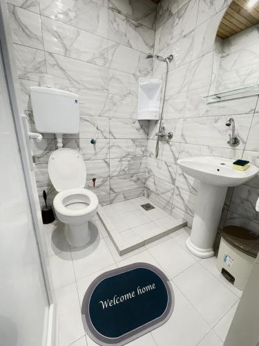 a white bathroom with a toilet and a sink at Becic Apartments in Ulcinj