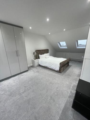a bedroom with a bed and two skylights at Studio Flat near wembley arena in Wealdstone