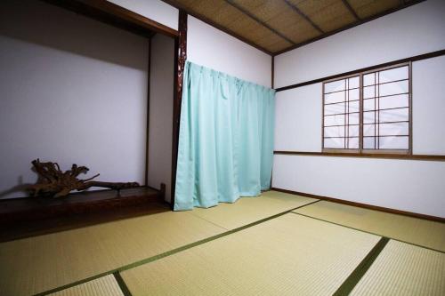 an empty room with a blue curtain and a window at 福井駅裏ハウス325貸切民泊 一日一組限定 駅から徒歩7分家族連れ団体様歓迎 安い in Fukui