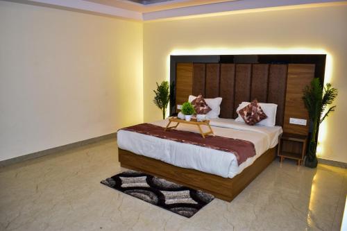 a bedroom with a large bed with a wooden headboard at HOTEL YASH PALACE Near IGI Airport in New Delhi