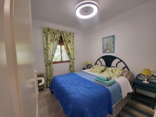 a bedroom with a blue bed and a window at Albadomus in Denia
