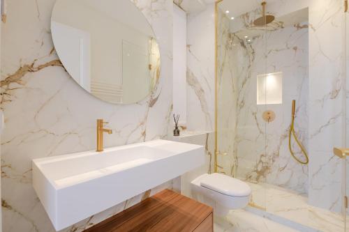 une salle de bain blanche avec un lavabo et des toilettes dans l'établissement La Guitare 23 - Large modern studio with balcony in center of Cannes, just behind Grand Hotel, à Cannes