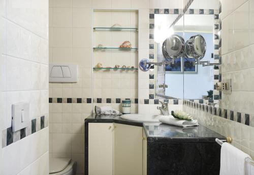 a bathroom with a sink and a mirror and a toilet at Casa del Mandolino - Cozy Apt near the Station! in Venice