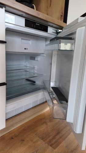 an empty refrigerator with its door open in a kitchen at Nature Getaway with Private Sauna, Wooden Soaking Hot Tub & Champagne Welcome in Nova Vas