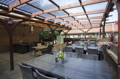 an outdoor patio with a wooden table and chairs at Randbøldal Camping & Cabins in Randbøl