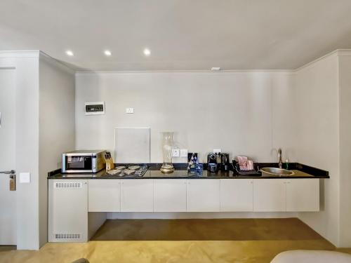 a kitchen with a counter top with a microwave at Rouge on Rose Boutique Hotel in Cape Town