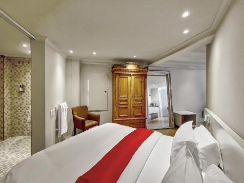 a bedroom with a bed with a red stripe on it at Rouge on Rose Boutique Hotel in Cape Town