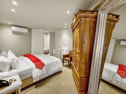 a hotel room with two beds and a mirror at Rouge on Rose Boutique Hotel in Cape Town