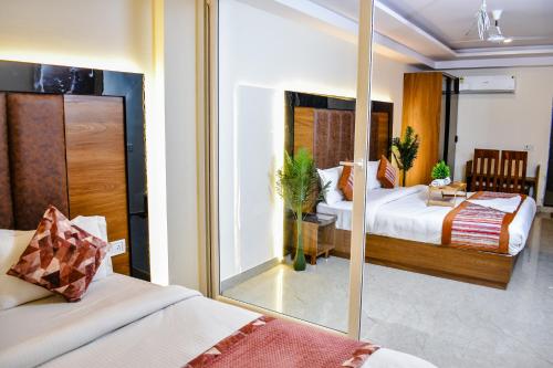 um quarto de hotel com duas camas e um espelho em HOTEL YASH PALACE em Nova Deli