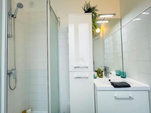 een witte badkamer met een wastafel en een douche bij Le MINTY Cocoon, bright & close to Paris in Maisons-Laffitte