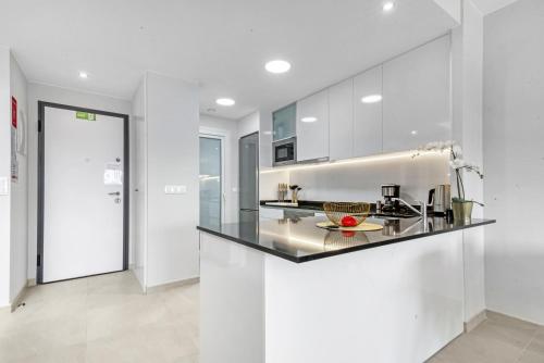 a kitchen with white cabinets and a counter top at Flamenca Village in Orihuela