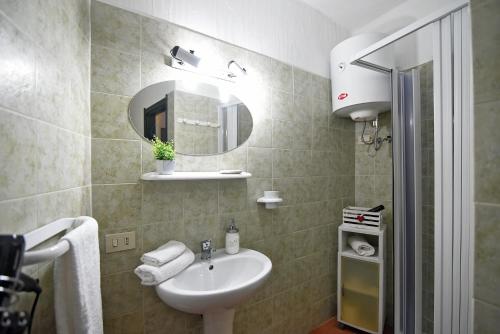un bagno con lavandino e specchio di Il Portoncino casa vacanze a Iglesias