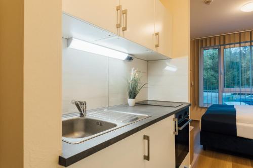 eine Küche mit einem Waschbecken und einem Bett in der Unterkunft MYKY Hotel Boardinghouse in Hamburg