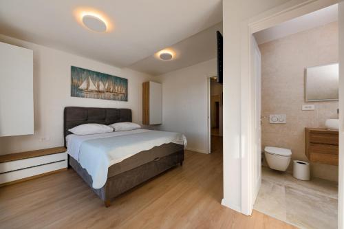 a bedroom with a large bed and a bathroom at Villa Senzen in Baška Voda