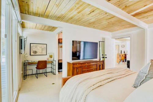 a bedroom with a bed and a flat screen tv at Zachs Siesta Key Beach House Heated Saltwater Pool Pet Friendly in Siesta Key