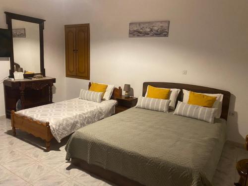 1 dormitorio con 2 camas con almohadas amarillas en Traditional Villa Efterpi en Halki