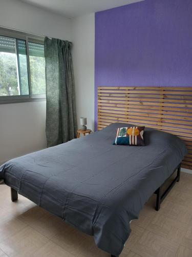 - une chambre avec un grand lit et un mur pourpre dans l'établissement Au cœur du coeur, à Andernos-les-Bains