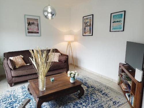 ein Wohnzimmer mit einem Sofa und einem Couchtisch in der Unterkunft Charmante Maison T2 de plein pied avec extérieur calme aux Arènes in Béziers