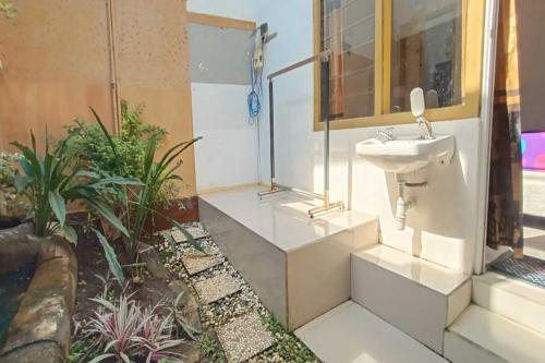 uma casa de banho com um lavatório e algumas plantas em OYO 93963 Homestay Kita Purworejo em Purworejo