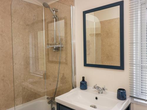 a bathroom with a shower and a sink and a mirror at Lakeland Dream South Lakeland Leisure Lodge in Carnforth