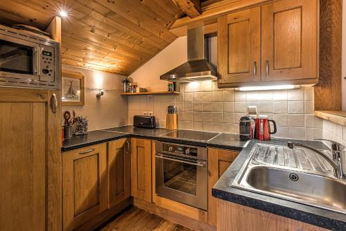 une cuisine avec des armoires en bois et un évier dans l'établissement La Tramousse - - Alpes Travel - Chamonix Centre - Sleeps 6, à Chamonix-Mont-Blanc