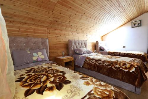 a bedroom with two beds in a wooden cabin at Samuela Cozy Retreat in Berat