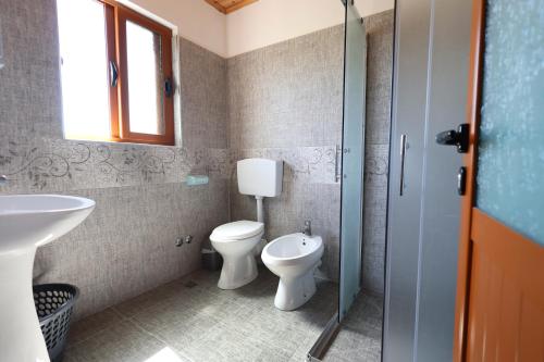 y baño con aseo y lavamanos. en Samuela Cozy Retreat en Berat