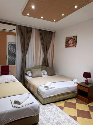 a bedroom with two beds and a table with a lamp at Becic Apartments in Ulcinj
