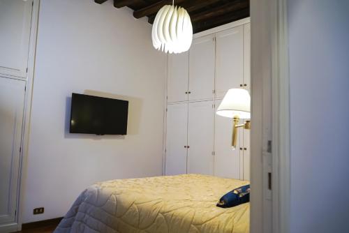 ローマにあるAppartamento Roma centroのベッドと壁にテレビが掛かった寝室