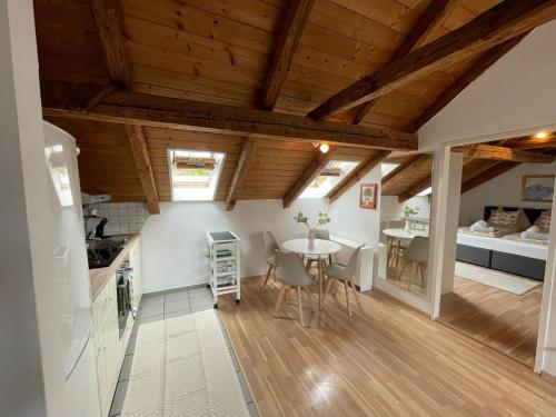 a kitchen and dining room with a table and a bed at BullsLiving Seeapartment 6 Am Corso in Velden am Wörthersee