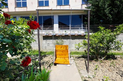 a swing in front of a house with red roses at Samuela Cozy Retreat in Berat