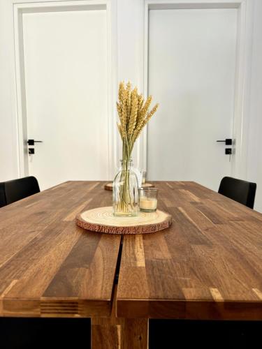 a wooden table with a vase of flowers on it at Downtown apartment - Premium in Kamena Vourla