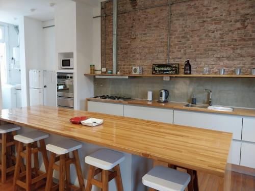 a kitchen with a wooden counter top and stools at SANTELMO in Buenos Aires