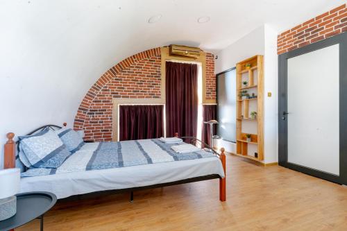 - une chambre avec un lit et un mur en briques dans l'établissement Studio77 maisonette, à Veliko Tarnovo