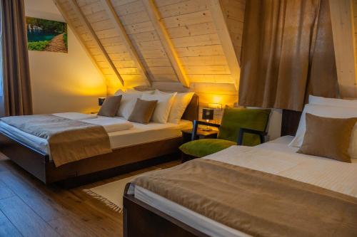 a bedroom with two beds and a desk with a chair at PLITVICKA KUCA M - Holiday Lodge in Plitvička Jezera