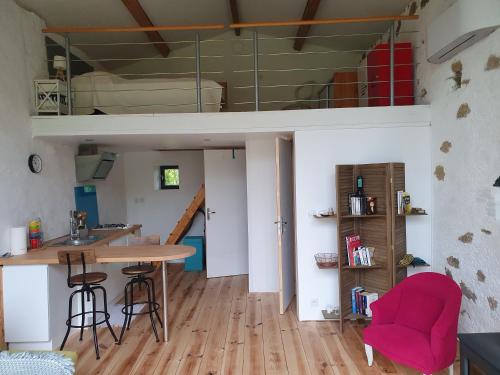 une chambre avec une table, des chaises et une mezzanine dans l'établissement La Grange de Pierre, à Saint-Martin-du-Fouilloux