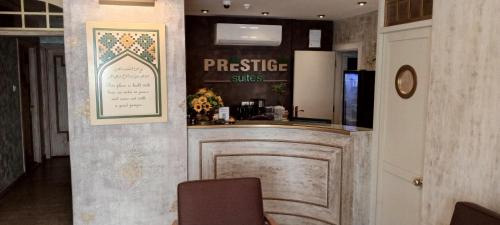 a bar in a restaurant with a sign on the wall at Prestige Hotel Suites - برستيج للشقق الفندقية in Amman