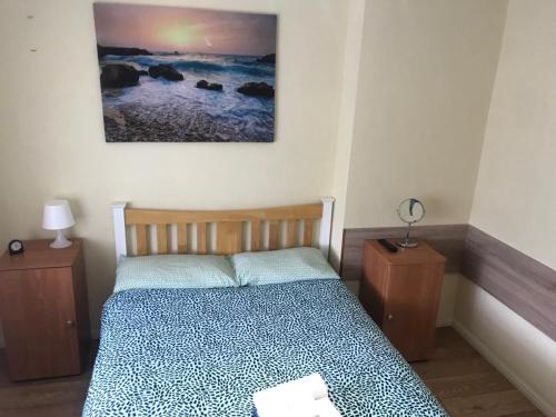1 dormitorio con 1 cama y 2 mesitas de noche en Becontreelodge, en Dagenham