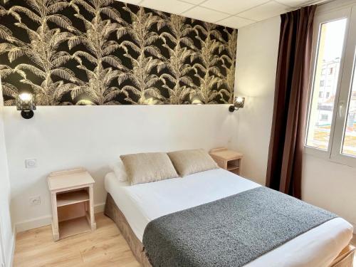 サン・ラファエルにあるオテル ド フロールのベッドルーム1室(ベッド1台付)が備わります。壁に壁画が飾られています。