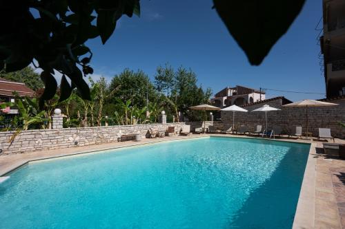 una gran piscina azul con sillas y sombrillas en Kaiafas Lake Hotel, en Kaiafas