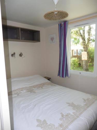a bedroom with a bed and a window at Mobil home Saint Georges de Didonne in Saint-Georges-de-Didonne