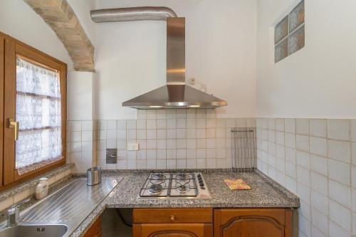 uma cozinha com fogão forno ao lado de um lavatório em Santa Lina - Gelsomino em Pomarance