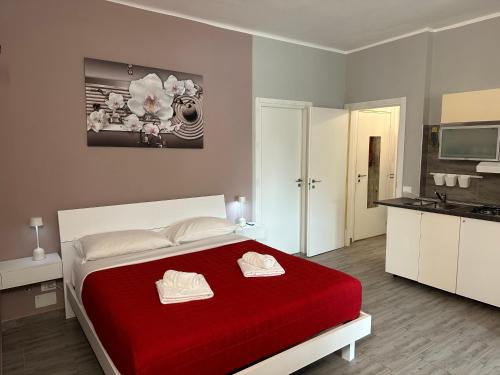 a bedroom with a red bed and a kitchen at B&B girasole in Verona