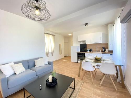 un salon avec un canapé bleu et une cuisine dans l'établissement Le Dandy-proche centre-neuf, à Châteauroux