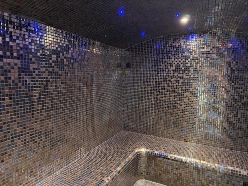 a bathroom with a shower with brown tiled walls at Goélia Résidence Du Parc in Gonneville-sur-Honfleur