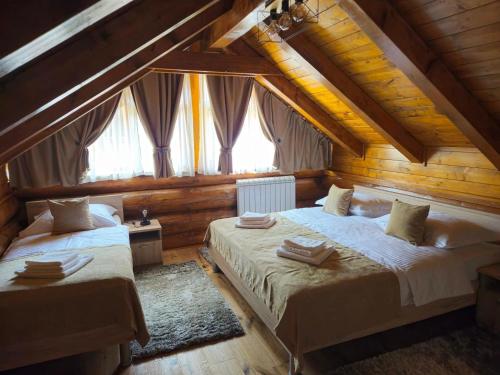 a bedroom with two beds in a wooden house at Villa Korina in Fužine