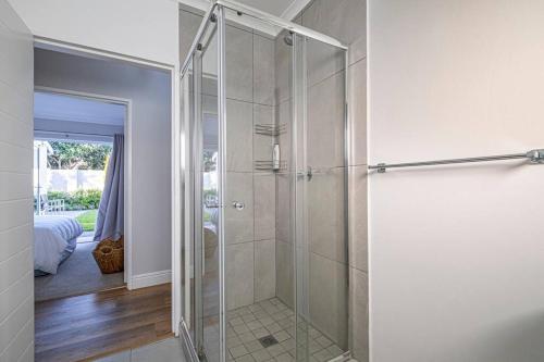 a shower with a glass door in a bathroom at The River House - Addo Elephant Park in Gqeberha