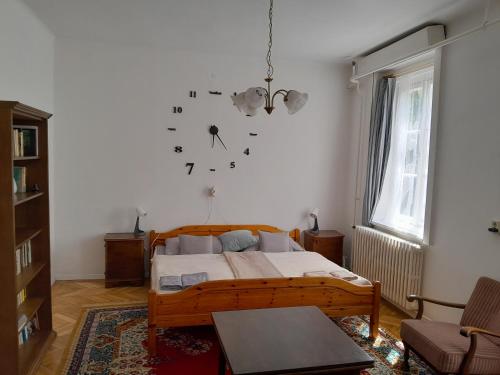 a bedroom with a bed and a clock on the wall at Tilia Ház in Salgótarján